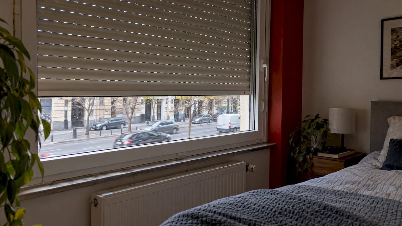 Leengedett redőny egy zajos utcára néző hálószobaablakon
